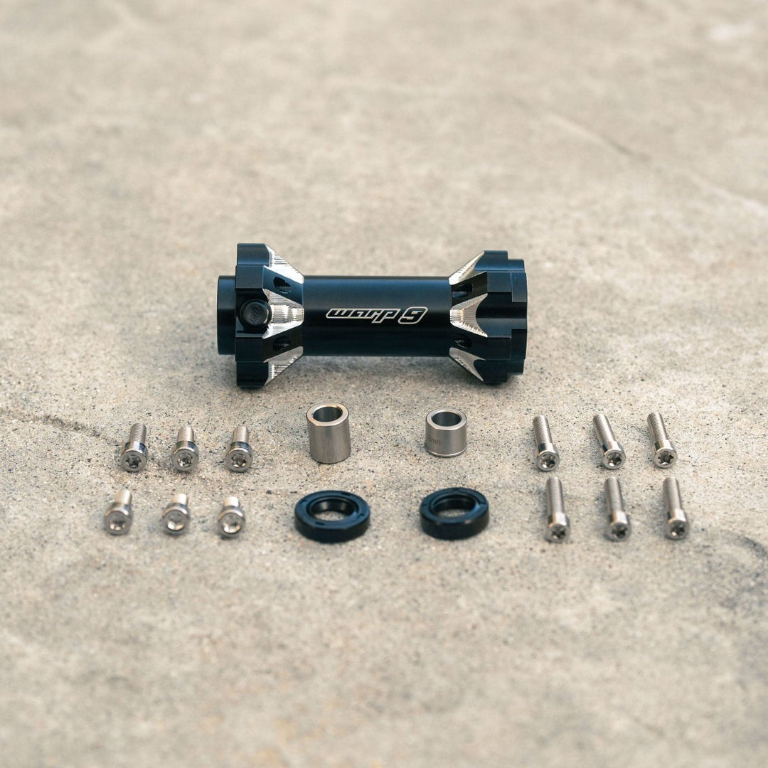 Warp 9 jackshaft kit with components, including black jackshaft, bolts, seals, and distance tubes