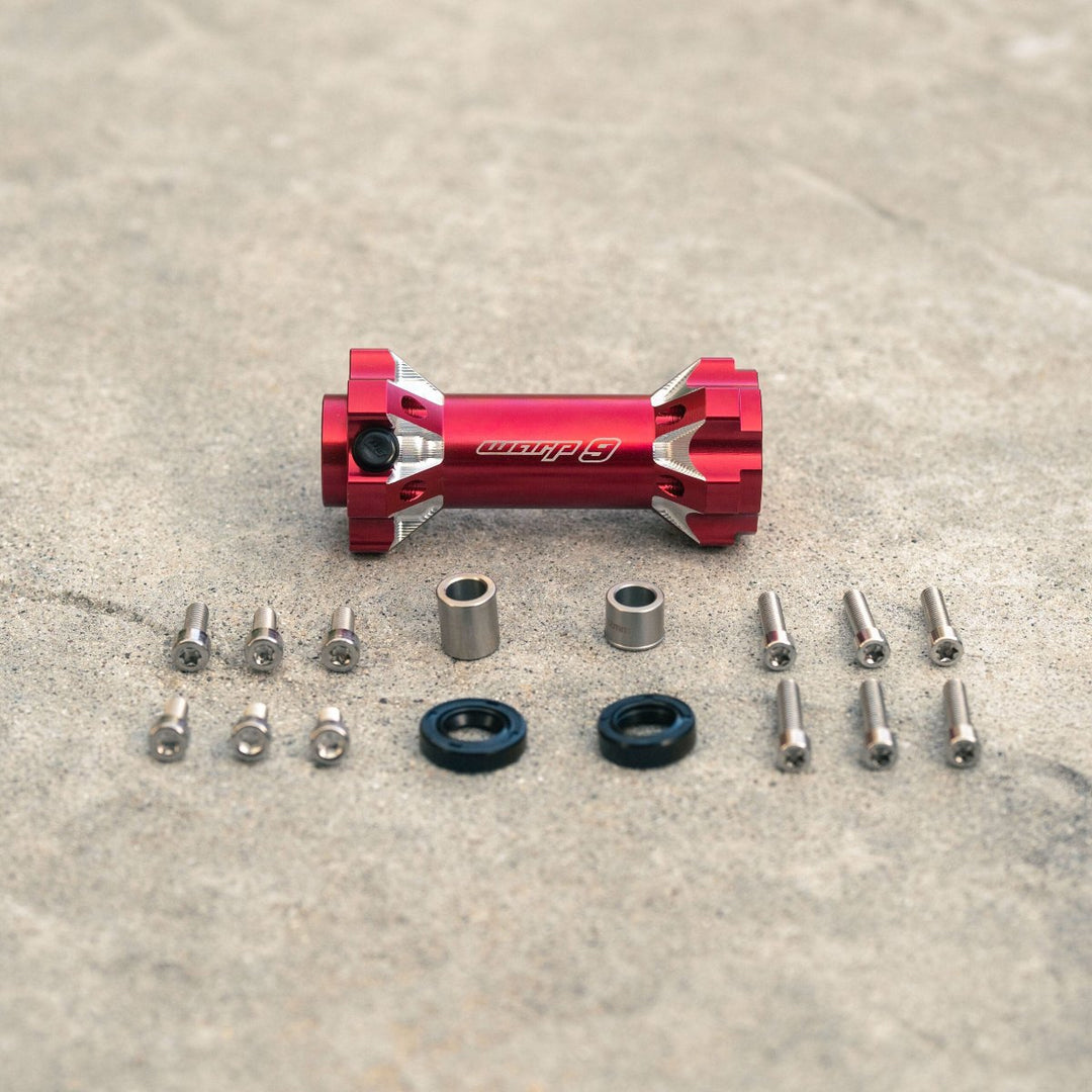 Warp 9 jackshaft kit in red with components, including bolts, seals, and distance tubes